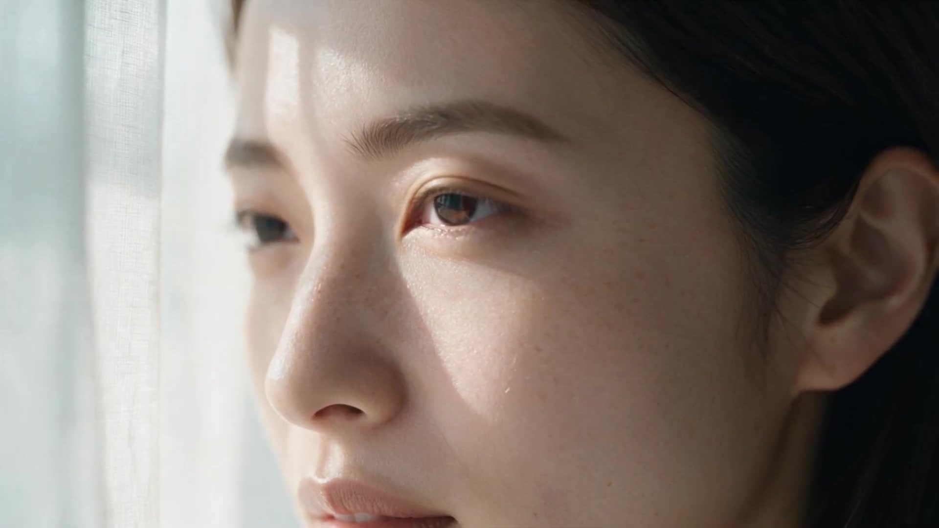 窓から差す光。横顔から肌の近景へ。